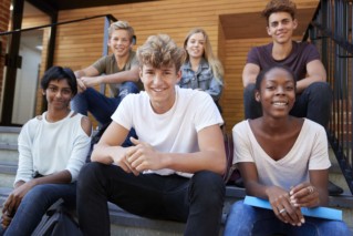 group-of-teenage-students-socialising-on-college