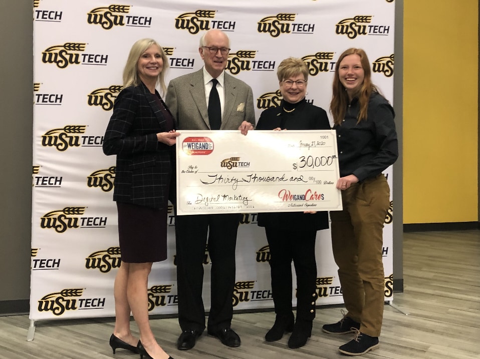 4 people holding a check wrote out to WSU Tech for $10,000 from Weigand and Son's Inc