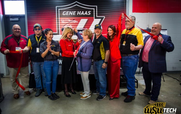 Group photo of people cutting a ribbon inside of the machining lab title Gene Haas Innovation Lab