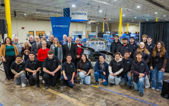 Group of Students, WSU Tech official and Wichita Public School officials stand in front of student constructed plane.