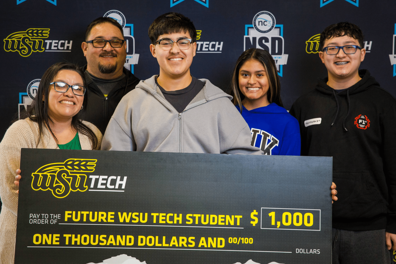 Signing Day Check Group Photo WSU Tech National Signing Day group photo of family with student who just committed to attending WSUT - holding the big thousand dollar check