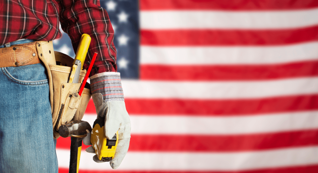 student-resources-hub-veterans-assistance Worker with a tool belt and measuring tape stands in front of an American flag, representing veteran career training and workforce education opportunities.