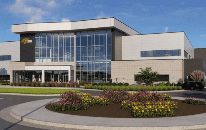 New National Center for Aviation Training building with large glass facade, landscaped circular flowerbeds and shrubs, parking area with cars, blue sky with clouds, and red “CROSSLAND TESSERE” text at the bottom right.